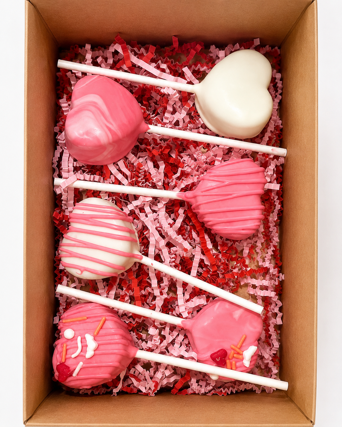 Pink and white heart-shaped cake pops in a gift box